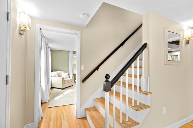 staircase featuring baseboards and wood finished floors