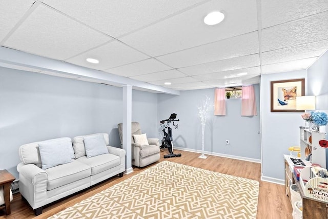 living room with a paneled ceiling, recessed lighting, baseboards, and wood finished floors