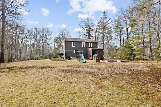 rear view of house with a playground and a chimney