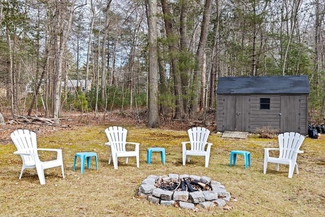 view of yard with a fire pit, a storage unit, and an outdoor structure