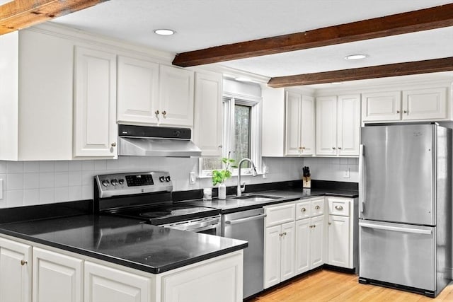 kitchen with white cabinets, under cabinet range hood, stainless steel appliances, and a sink