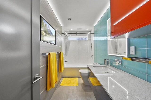 full bathroom with toilet, tile walls, bathing tub / shower combination, and vanity