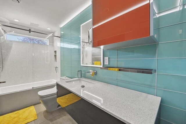 full bathroom with vanity, toilet, shower / bath combination, tile walls, and decorative backsplash
