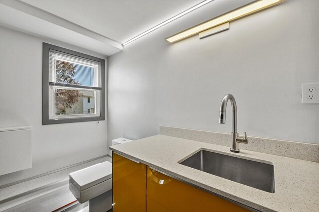 kitchen featuring a sink and light stone countertops