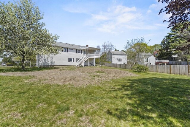 view of yard with stairway, a deck, and fence