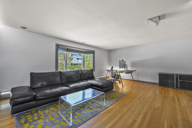living room featuring a baseboard heating unit and wood finished floors