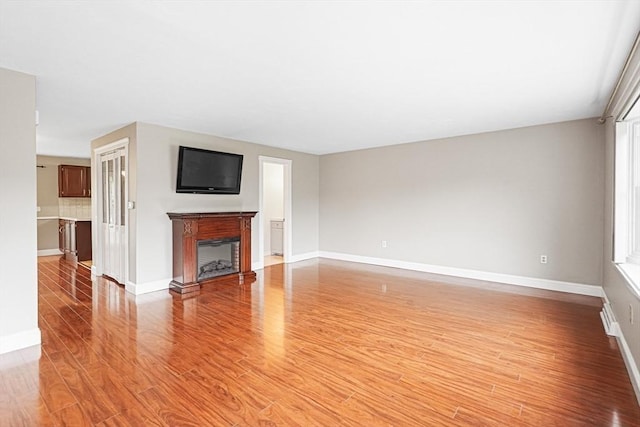 24 Highcrest Park Unit 24, Webster, MA 01570 - unfurnished living room featuring light wood-type flooring, baseboards, and a glass covered fireplace