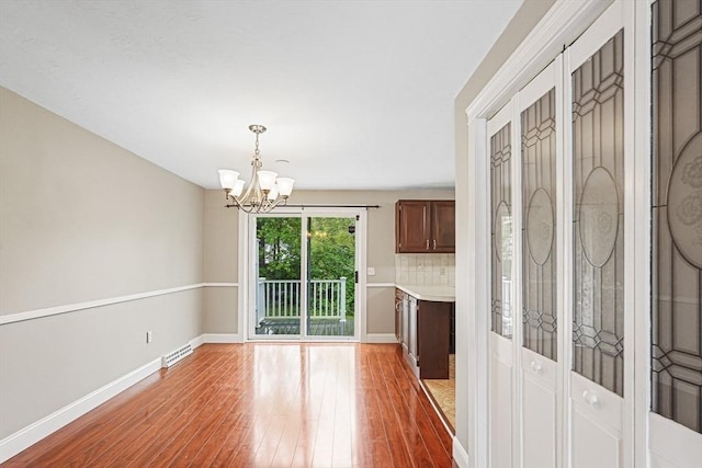 24 Highcrest Park Unit 24, Webster, MA 01570 - unfurnished dining area featuring hardwood / wood-style flooring, a chandelier, and baseboards