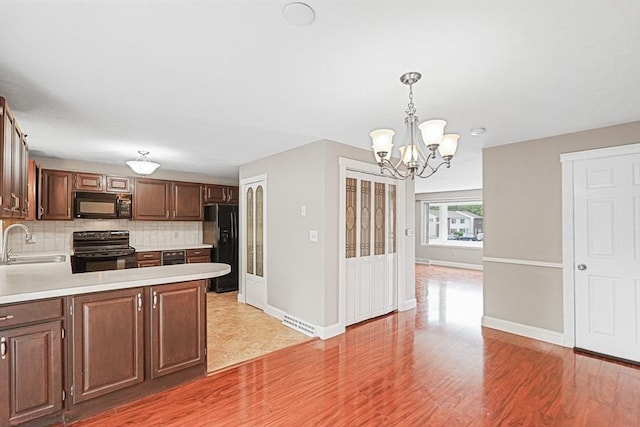 24 Highcrest Park Unit 24, Webster, MA 01570 - kitchen with black appliances, light countertops, backsplash, a chandelier, and a sink