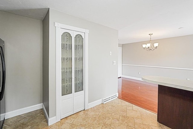 24 Highcrest Park Unit 24, Webster, MA 01570 - kitchen featuring stone tile floors, a chandelier, baseboards, refrigerator, and decorative light fixtures