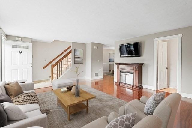 24 Highcrest Park Unit 24, Webster, MA 01570 - living area featuring stairs, baseboards, wood finished floors, and a glass covered fireplace