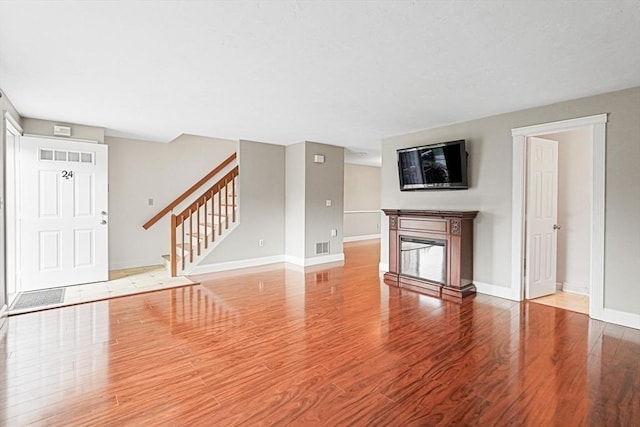24 Highcrest Park Unit 24, Webster, MA 01570 - unfurnished living room with wood finished floors, stairway, baseboards, and a glass covered fireplace