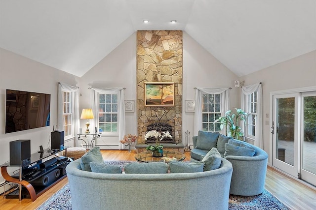 living room with a fireplace, high vaulted ceiling, and hardwood / wood-style flooring