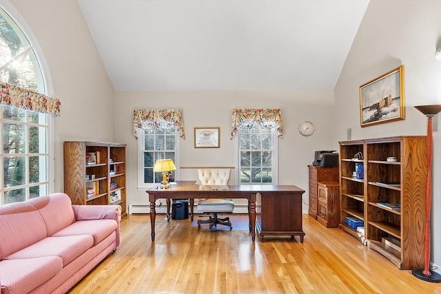 office area with light wood-type flooring, a baseboard radiator, and plenty of natural light