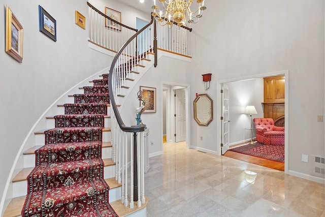 stairs featuring a high ceiling and a notable chandelier