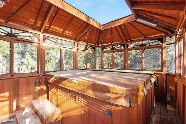 sunroom / solarium with lofted ceiling with beams, a jacuzzi, and wood ceiling