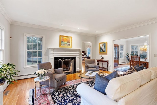 living room with wood-type flooring, a baseboard heating unit, and crown molding