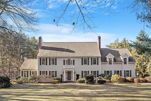 colonial home featuring a front lawn