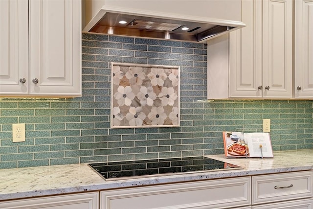 kitchen featuring custom exhaust hood, white cabinetry, black electric cooktop, and light stone countertops