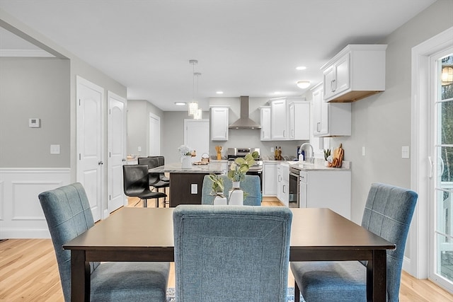 dining space with light hardwood / wood-style flooring and sink