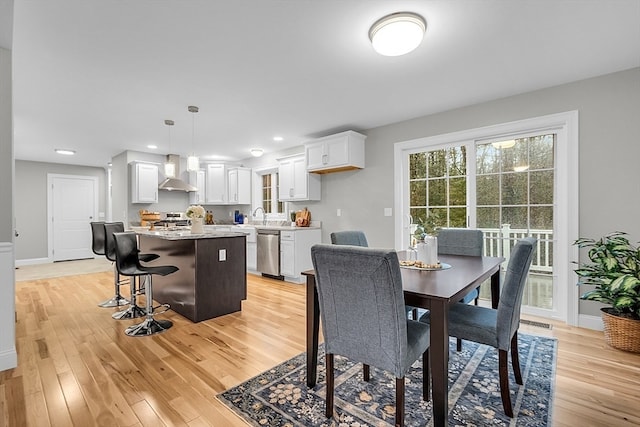 dining space with light wood-type flooring and sink