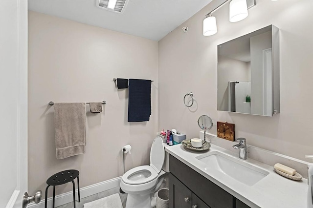 bathroom with a shower with door, vanity, and toilet