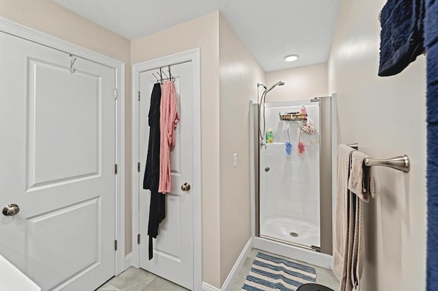 bathroom featuring a shower with shower door and tile patterned flooring