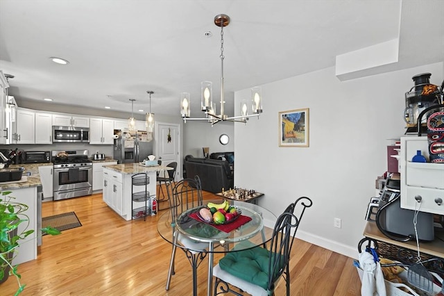 dining room with a notable chandelier and light hardwood / wood-style floors