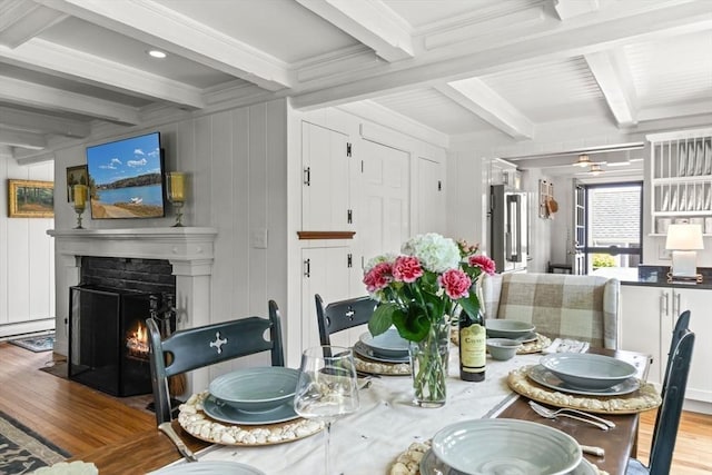 751 Crowell Rd, Chatham, MA 02650 - dining room with wood finished floors, beam ceiling, crown molding, a fireplace with flush hearth, and a decorative wall