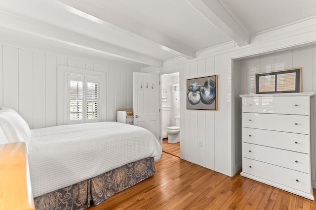 751 Crowell Rd, Chatham, MA 02650 - bedroom featuring beam ceiling, wood finished floors, a decorative wall, and connected bathroom