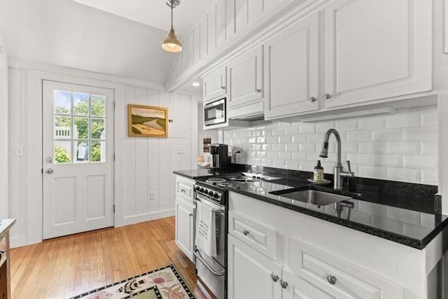 751 Crowell Rd, Chatham, MA 02650 - kitchen with a sink, stainless steel appliances, light wood-style flooring, decorative backsplash, and white cabinetry
