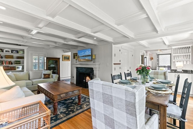 751 Crowell Rd, Chatham, MA 02650 - dining room with coffered ceiling, wood finished floors, beam ceiling, a warm lit fireplace, and crown molding