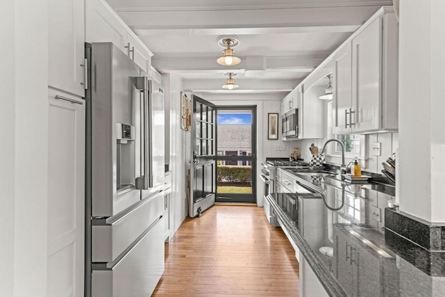 751 Crowell Rd, Chatham, MA 02650 - kitchen with premium appliances, a sink, light wood-style flooring, white cabinets, and beam ceiling