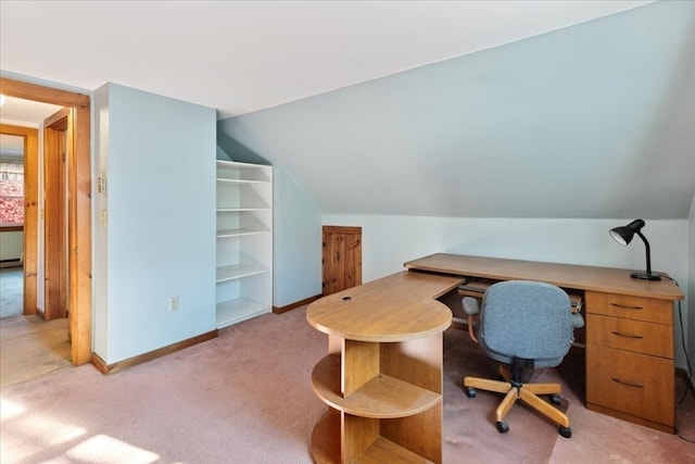 carpeted office space featuring vaulted ceiling