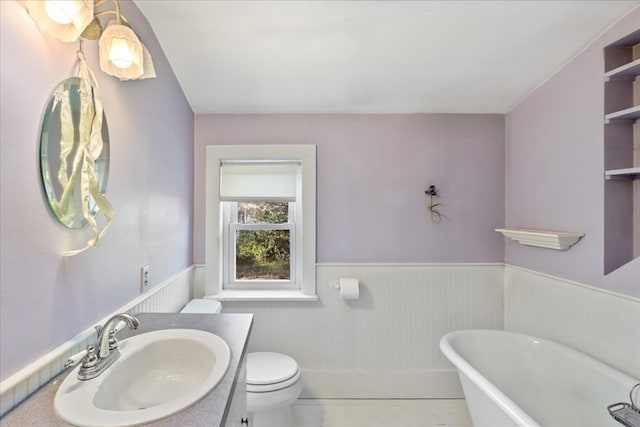 bathroom featuring a bathtub, vanity, tile patterned floors, and toilet