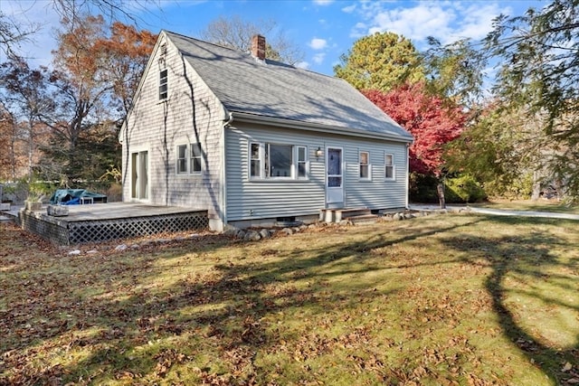 back of property with a lawn and a deck