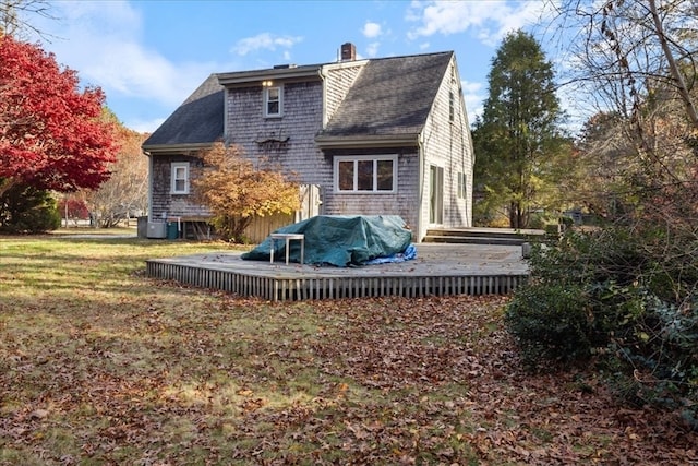 back of house with central air condition unit, a wooden deck, and a lawn