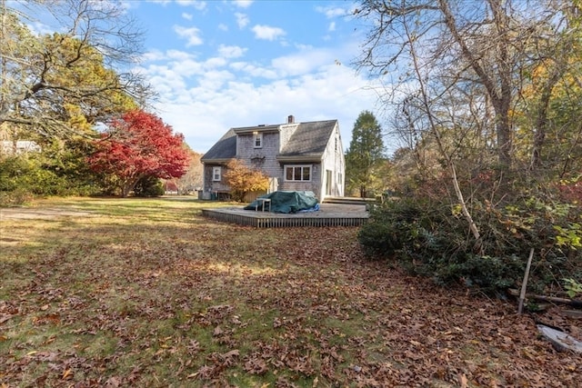 exterior space with a wooden deck and a lawn