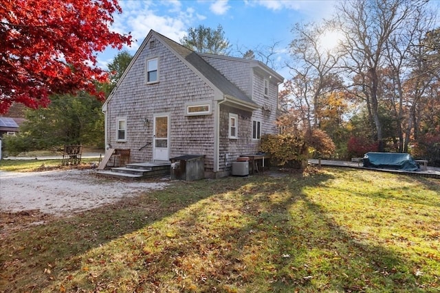 view of property exterior with central AC unit and a lawn