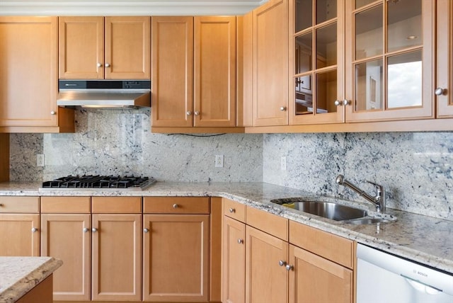 kitchen with under cabinet range hood, a sink, gas stovetop, light stone countertops, and dishwasher