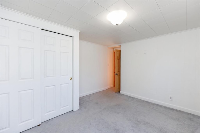 unfurnished bedroom with light colored carpet and a closet