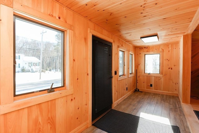 doorway to outside with wood walls, wood ceiling, and light hardwood / wood-style flooring