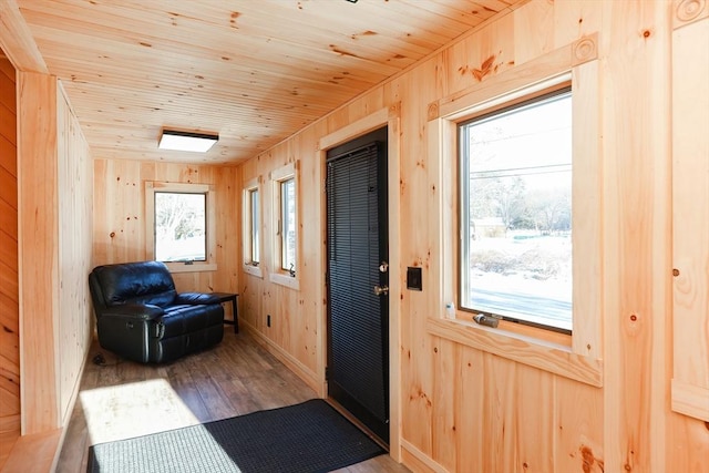 doorway to outside with a skylight, wood walls, hardwood / wood-style floors, and wood ceiling