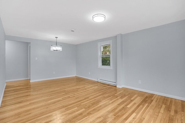 738 Piper Rd, West Springfield, MA 01089 - empty room with a baseboard heating unit, light wood-style floors, and a chandelier