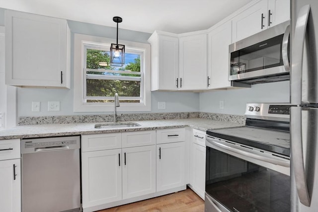 738 Piper Rd, West Springfield, MA 01089 - kitchen with appliances with stainless steel finishes, white cabinetry, decorative light fixtures, light wood-style flooring, and light stone counters