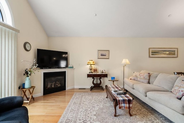 905 Village Ln Unit 905, Bellingham, MA 02019 - living area featuring wood finished floors, a glass covered fireplace, and vaulted ceiling