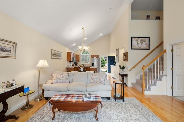 905 Village Ln Unit 905, Bellingham, MA 02019 - living area with a chandelier, stairs, light wood-type flooring, and high vaulted ceiling
