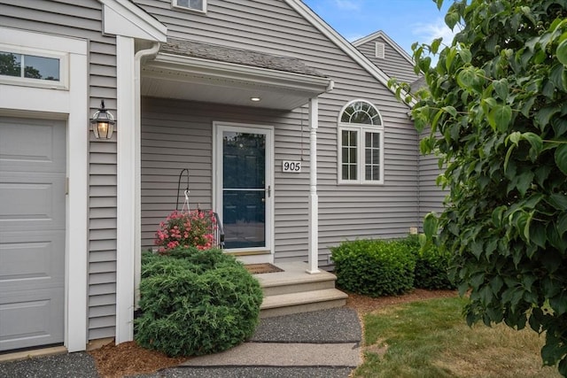 905 Village Ln Unit 905, Bellingham, MA 02019 - view of exterior entry with an attached garage and roof with shingles