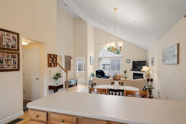 905 Village Ln Unit 905, Bellingham, MA 02019 - kitchen featuring high vaulted ceiling, light wood-type flooring, a chandelier, light countertops, and hanging light fixtures