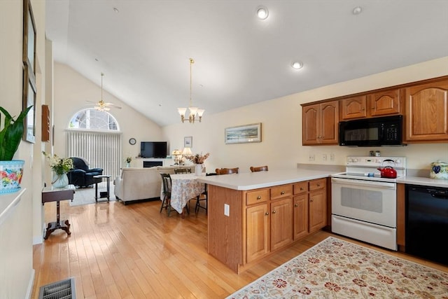 905 Village Ln Unit 905, Bellingham, MA 02019 - kitchen featuring black appliances, light countertops, a peninsula, light wood finished floors, and vaulted ceiling
